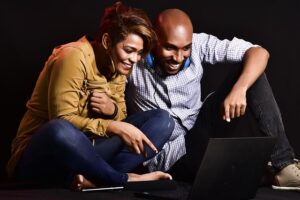 A man and a women watching a video on the laptop