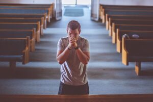 A man Praying on the church on his knees