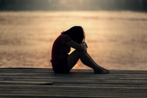 Girl sad sitting on the bridge